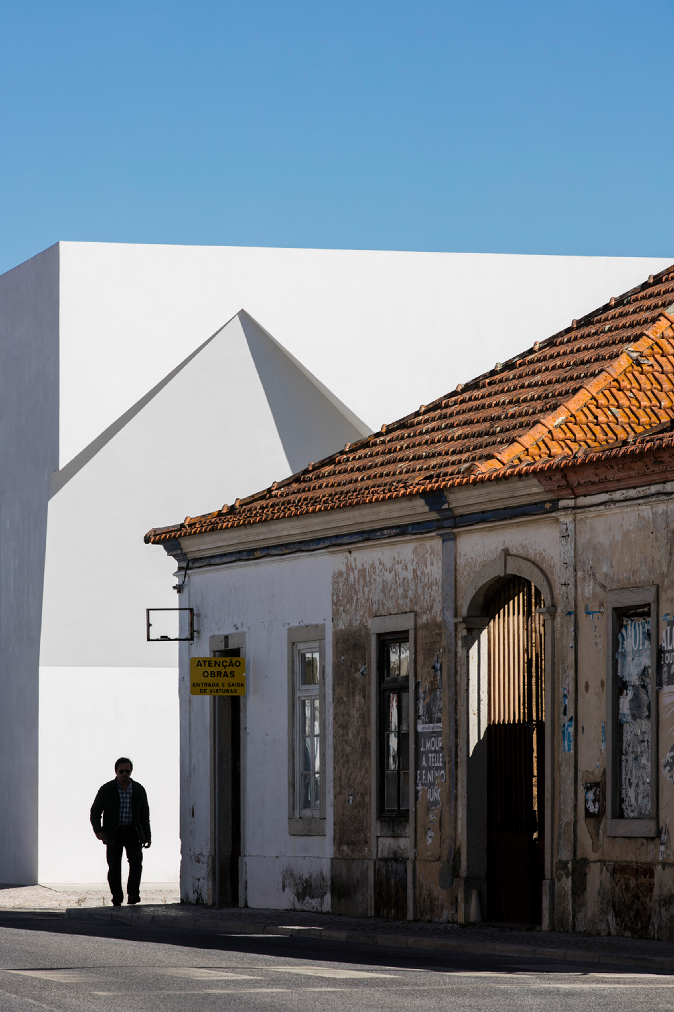 Irregular cutouts mark entrances to Aires Mateus' community centre in Portugal-16