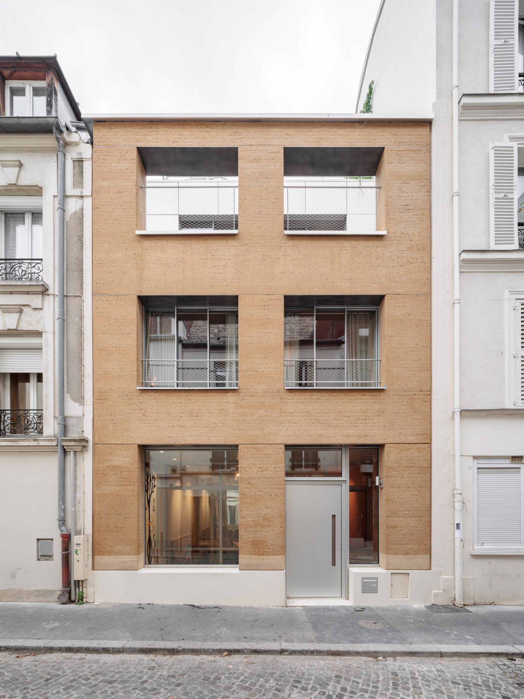 Rammed-earth wall fronts Parisian townhouse by Déchelette Architecture-4