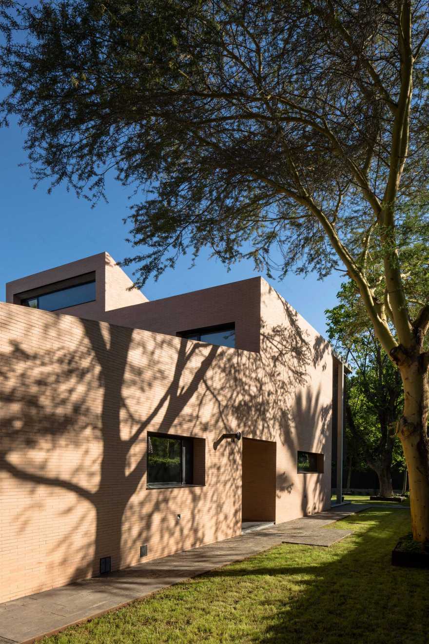 Concrete portico provides sheltered outdoor space at pink-brick house in Seville-22