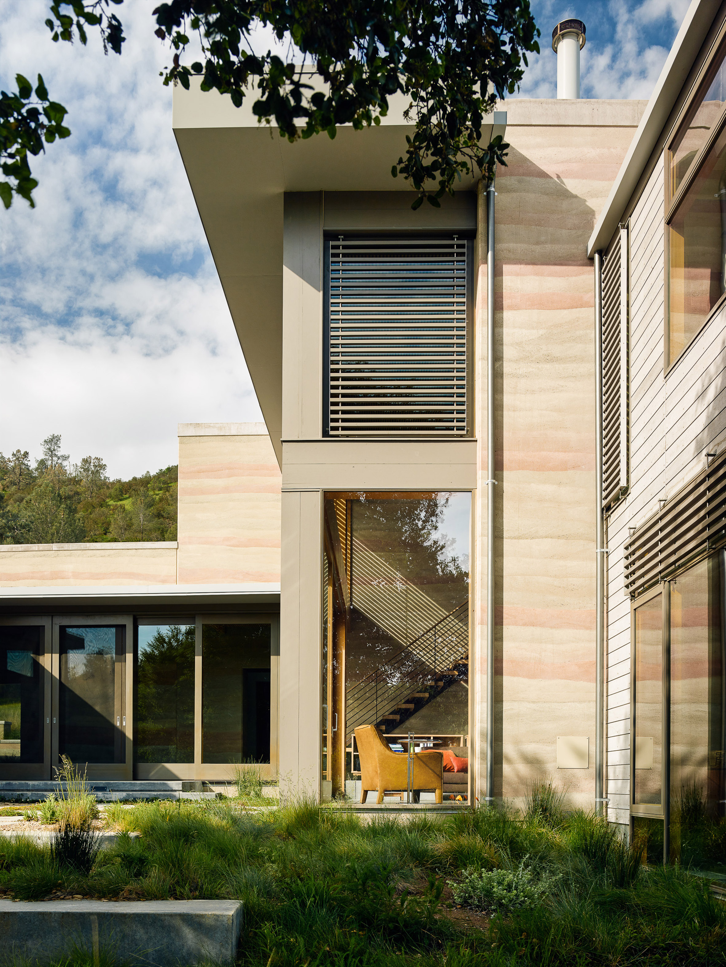 Stripey rammed-earth walls curve through holiday house in Californian walnut farm-10