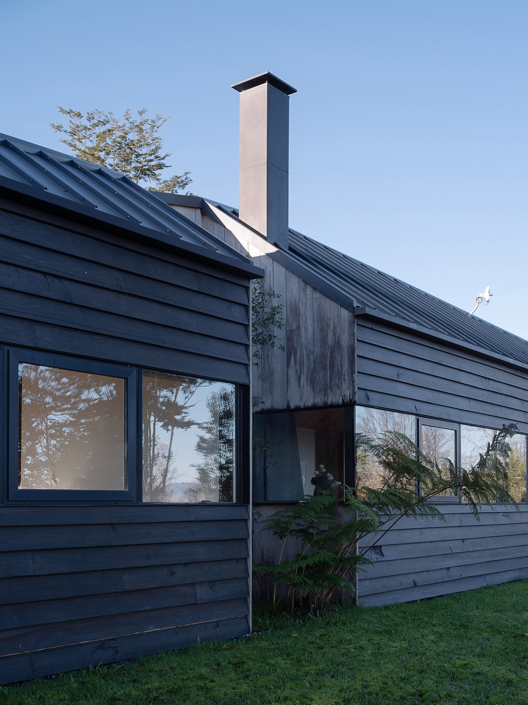 智利 Hebra Arquitectos 设计的 Apfel House | T 形木屋嵌入山丘,尽享美景-29