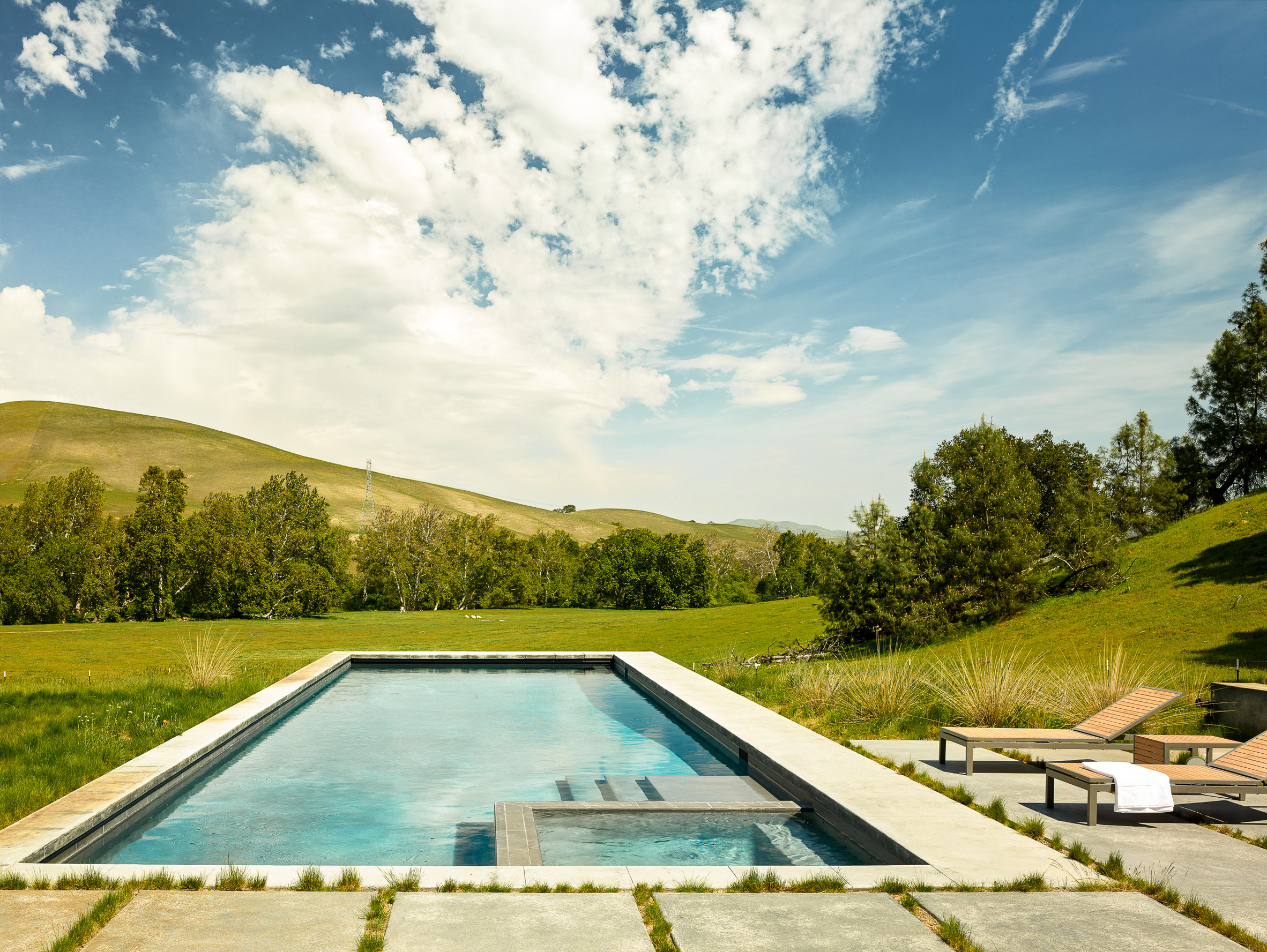 Stripey rammed-earth walls curve through holiday house in Californian walnut farm-27
