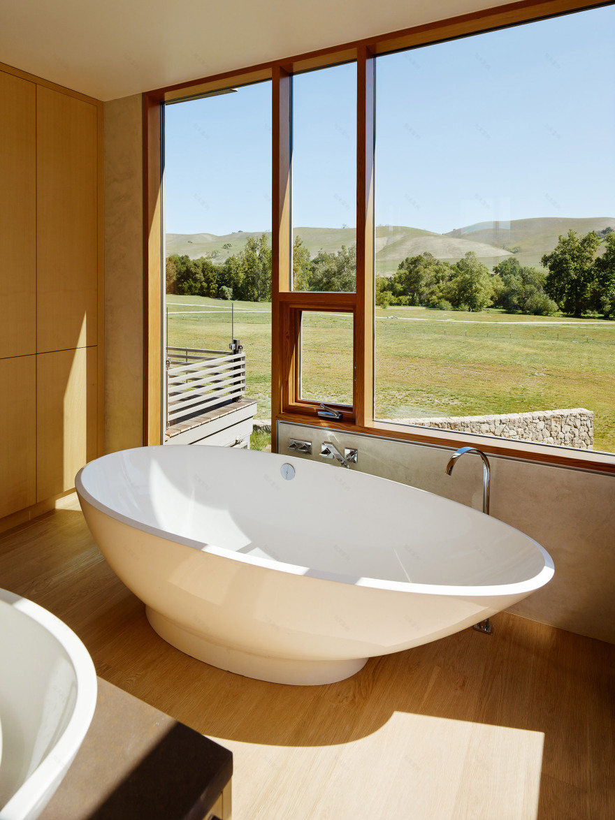 Stripey rammed-earth walls curve through holiday house in Californian walnut farm-24