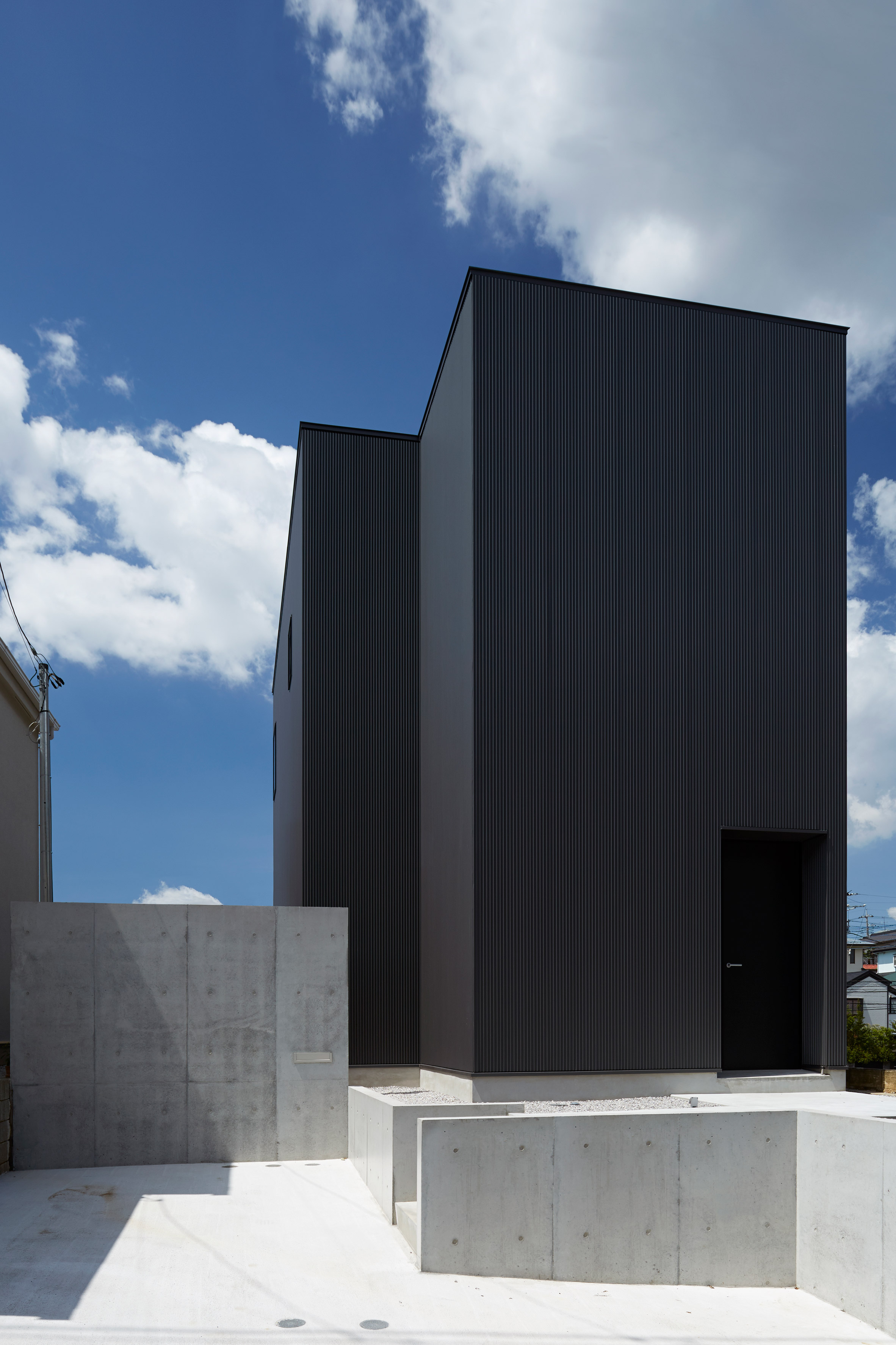 Black corrugated metal encases loft-inspired interiors of Japanese house by TakaTina-26