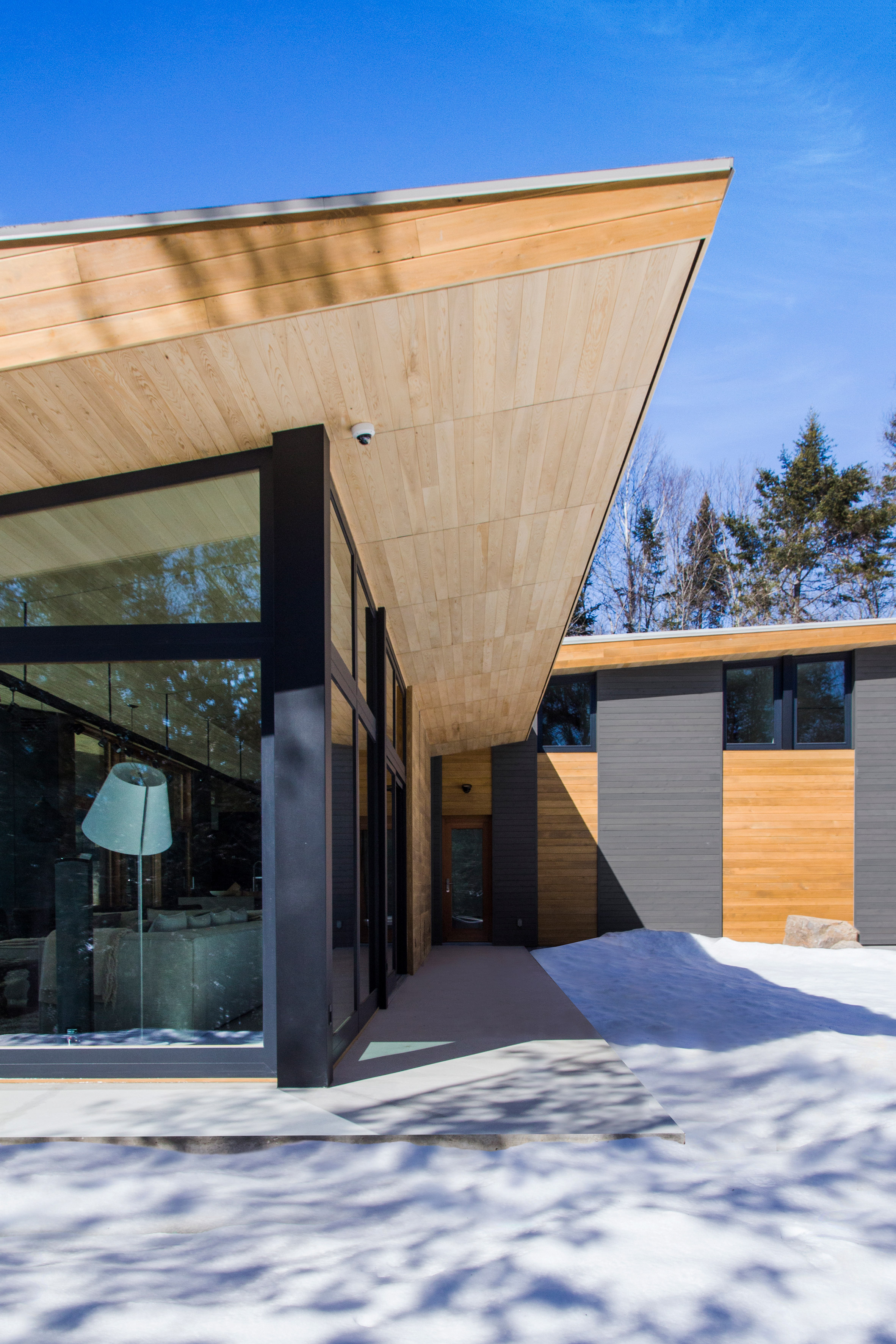 Quebec ski chalet by YH2 features V-shaped roof modelled on bird's wings-8