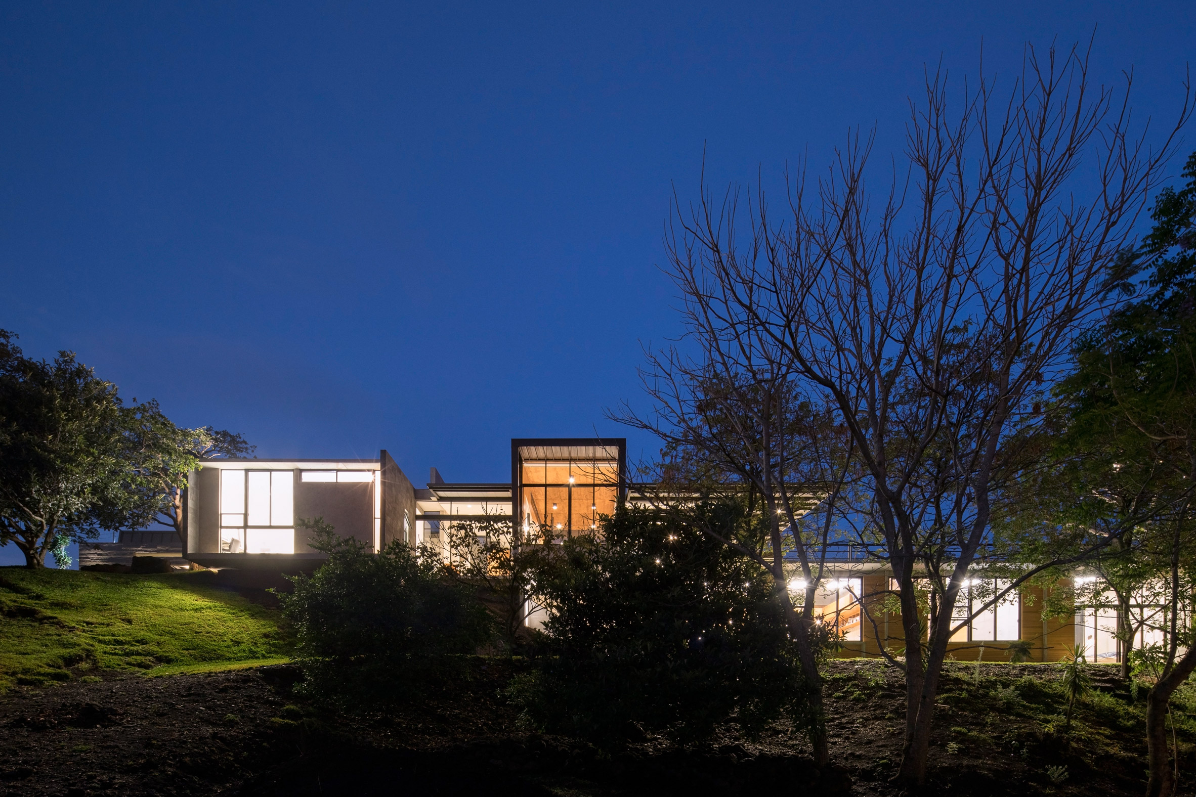 Grove of trees shades hillside Costa Rican house by Carazo Arquitectura-23