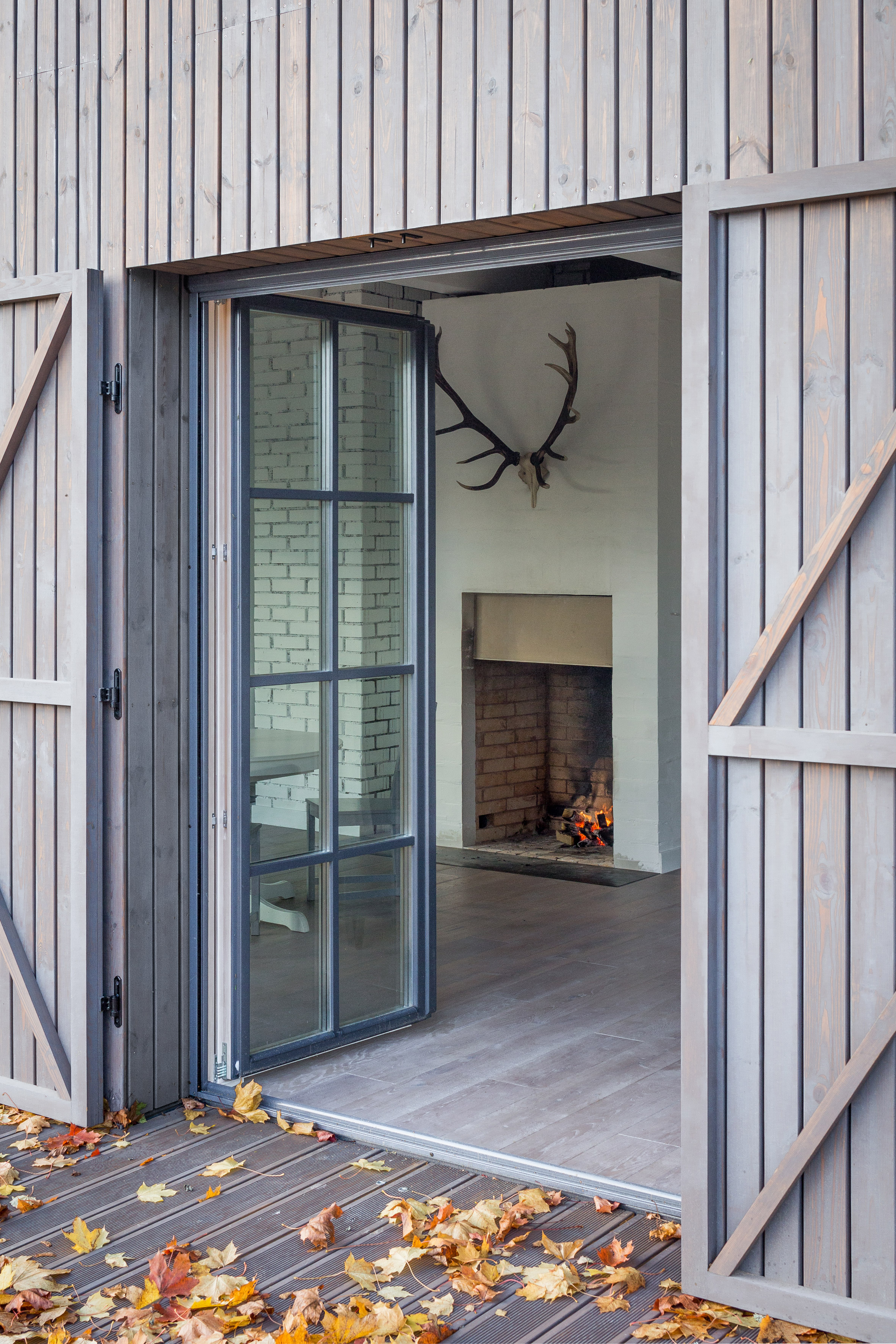 Aketuri Architektai conceals windows and doors behind large timber shutters at Lithuanian lakeside retreat-17