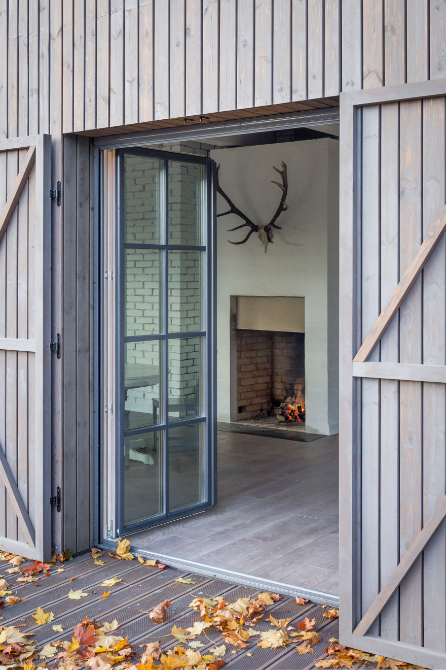 Aketuri Architektai conceals windows and doors behind large timber shutters at Lithuanian lakeside retreat-17