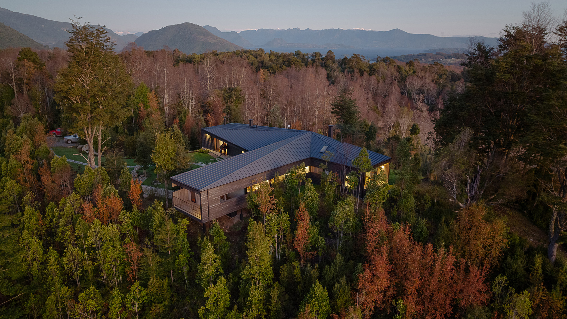 智利 Hebra Arquitectos 设计的 Apfel House | T 形木屋嵌入山丘，尽享美景-0