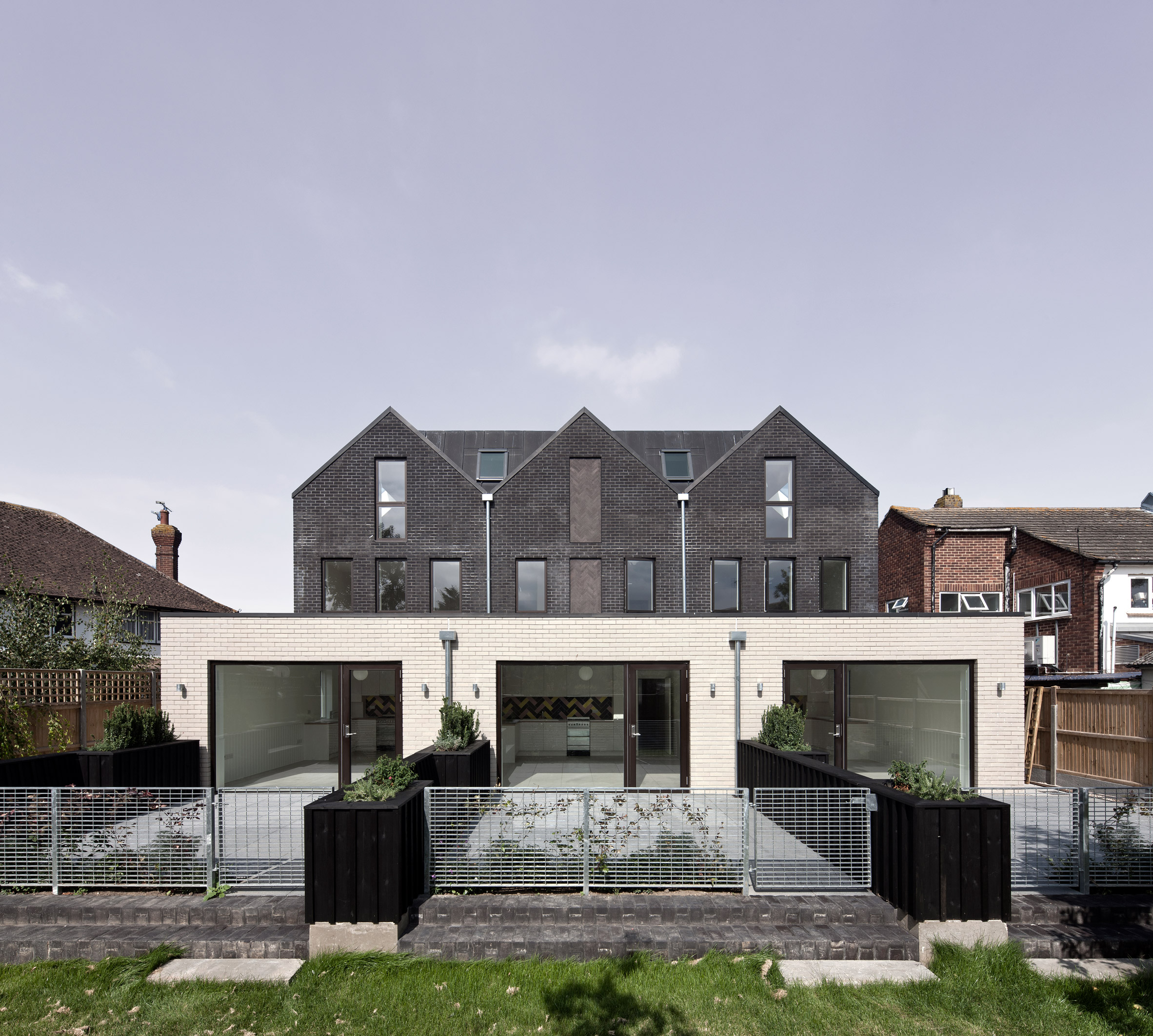 Denizen Works pairs black bricks with pointy panels for Whitstable housing-13