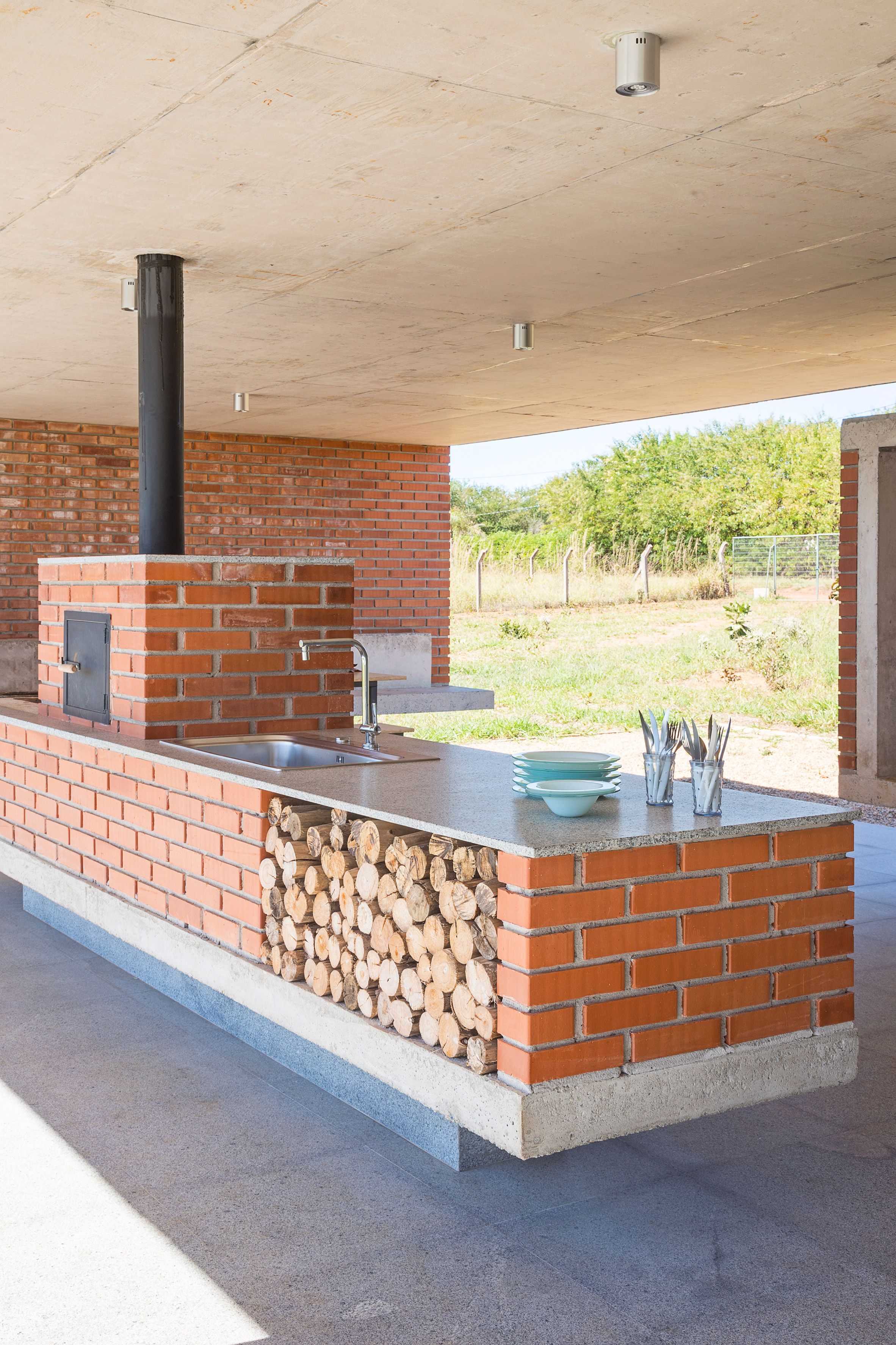 Concrete frame cradles brickwork walls of Bloco Arquitetos' rural Brasília residence-16