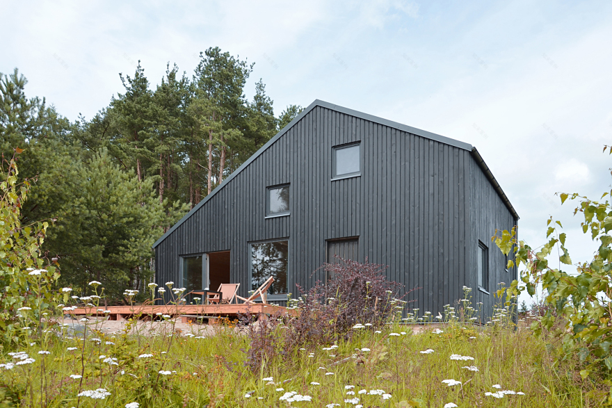 Black gabled house hewn from pine wood sits in the middle of a Polish forest-5