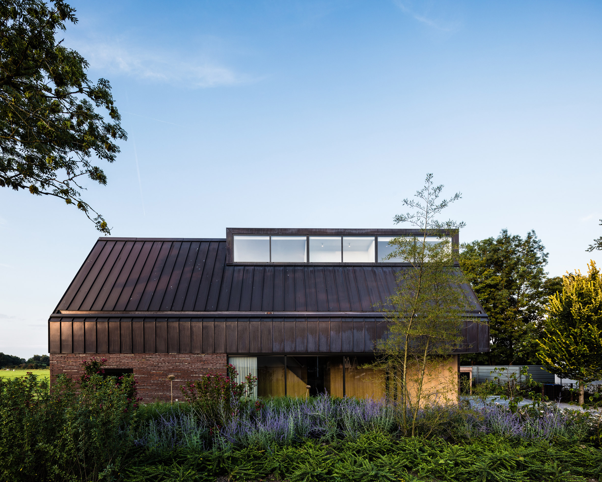 EVA Architecten's riverside house features brick and patinated copper-3