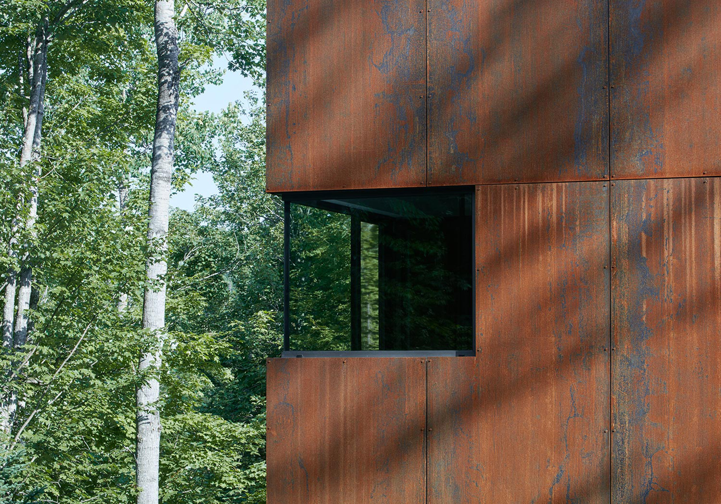 Canadian lake house by Paul Bernier features dark rusted metal cladding-4