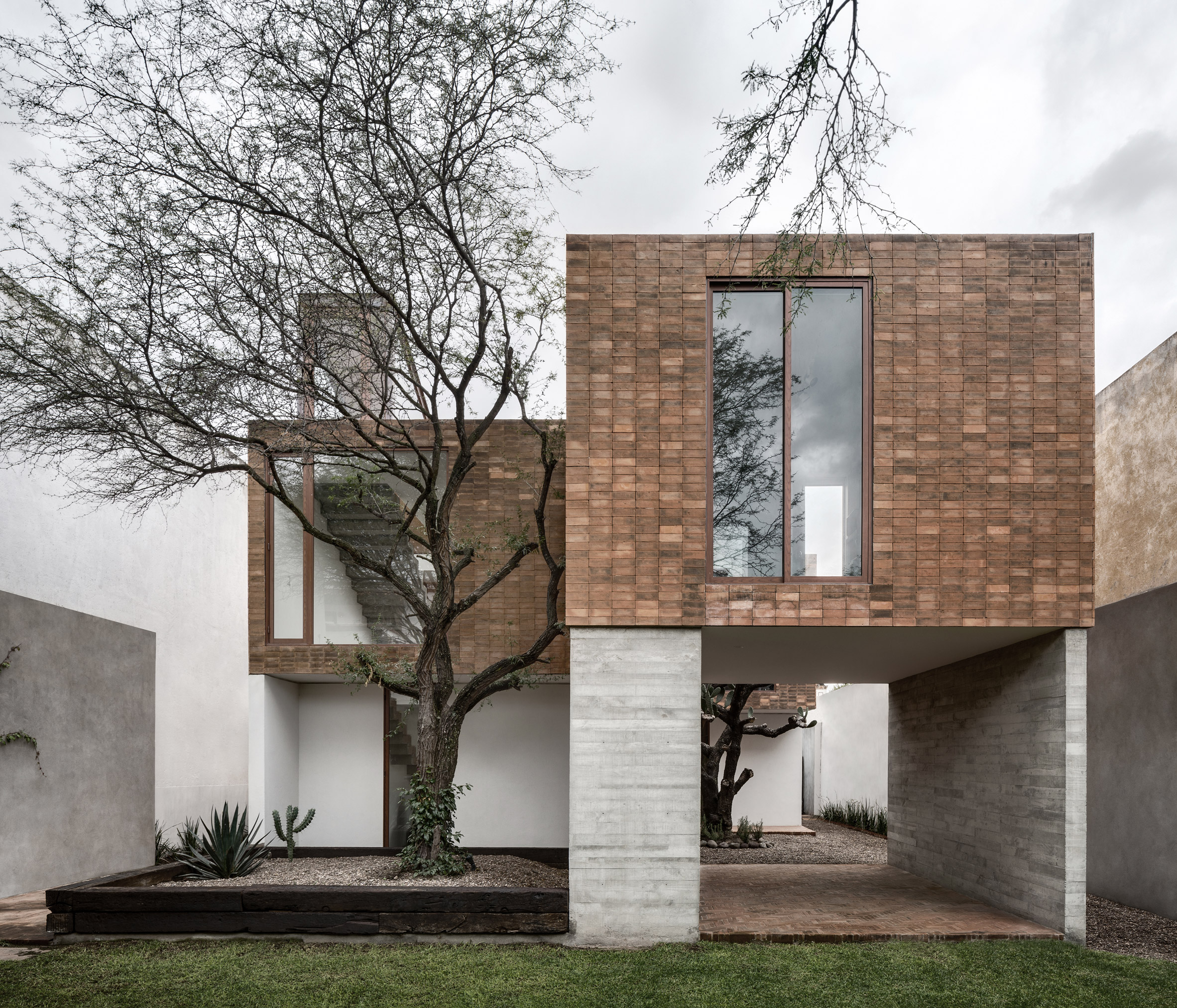 Clay brick and concrete Mexican house is set around a cactus tree-2