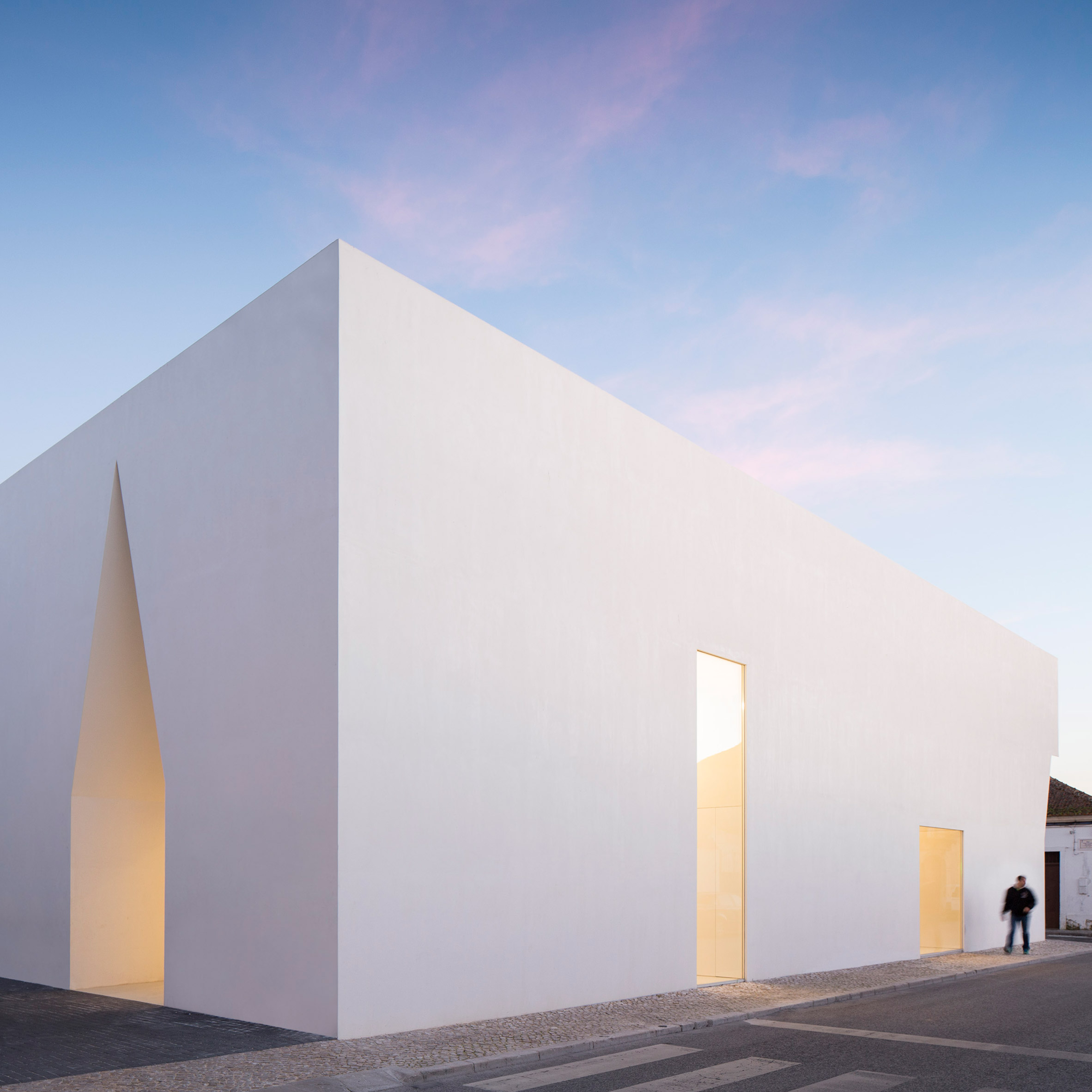 Irregular cutouts mark entrances to Aires Mateus' community centre in Portugal-0