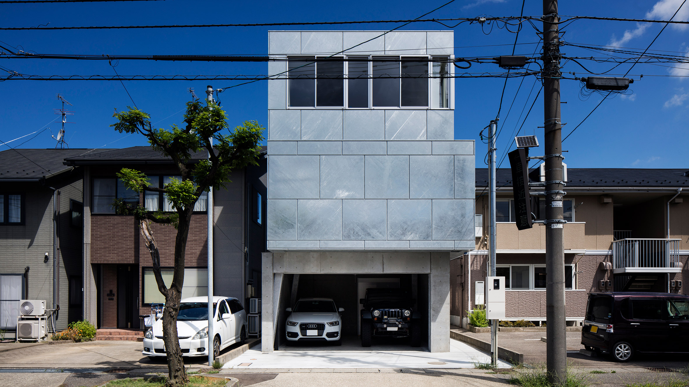 Galvanised steel panels cover irregularly stacked volumes of Japanese townhouse-0
