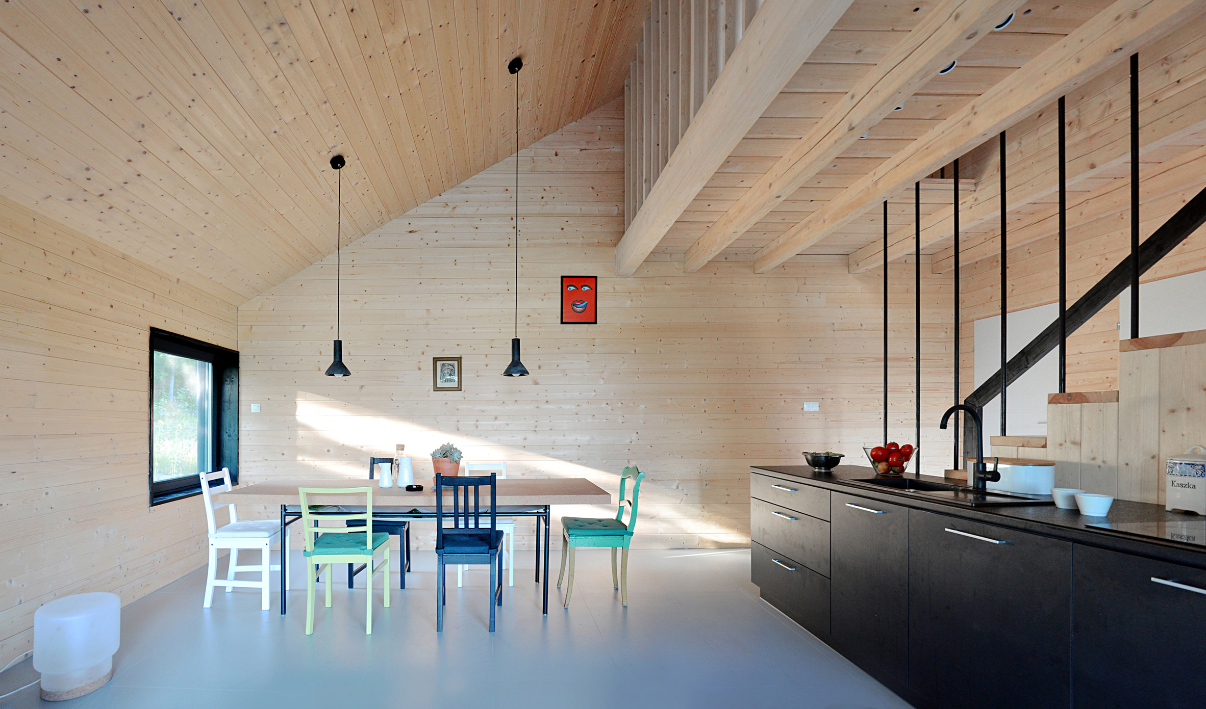 Black gabled house hewn from pine wood sits in the middle of a Polish forest-9