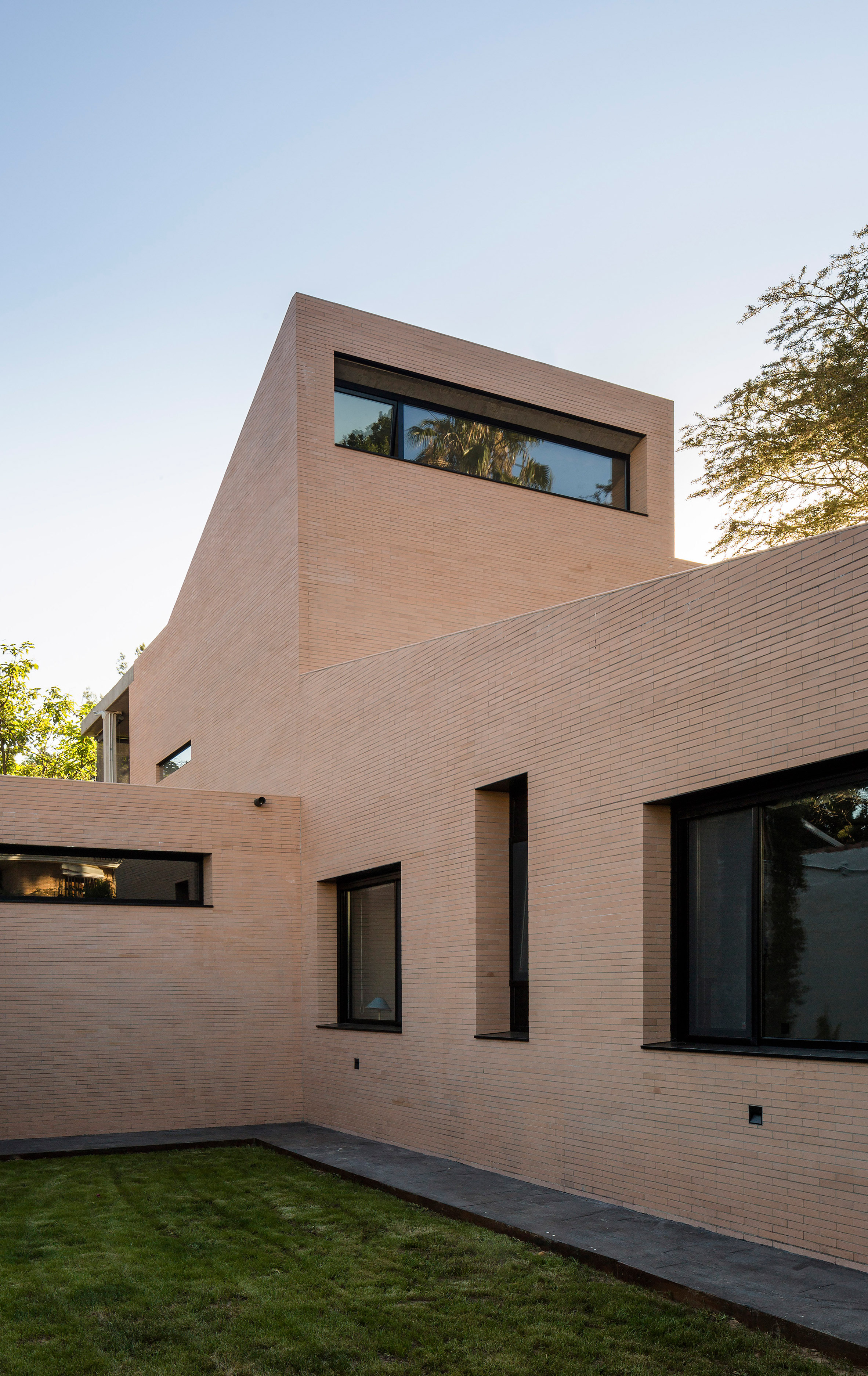 Concrete portico provides sheltered outdoor space at pink-brick house in Seville-5