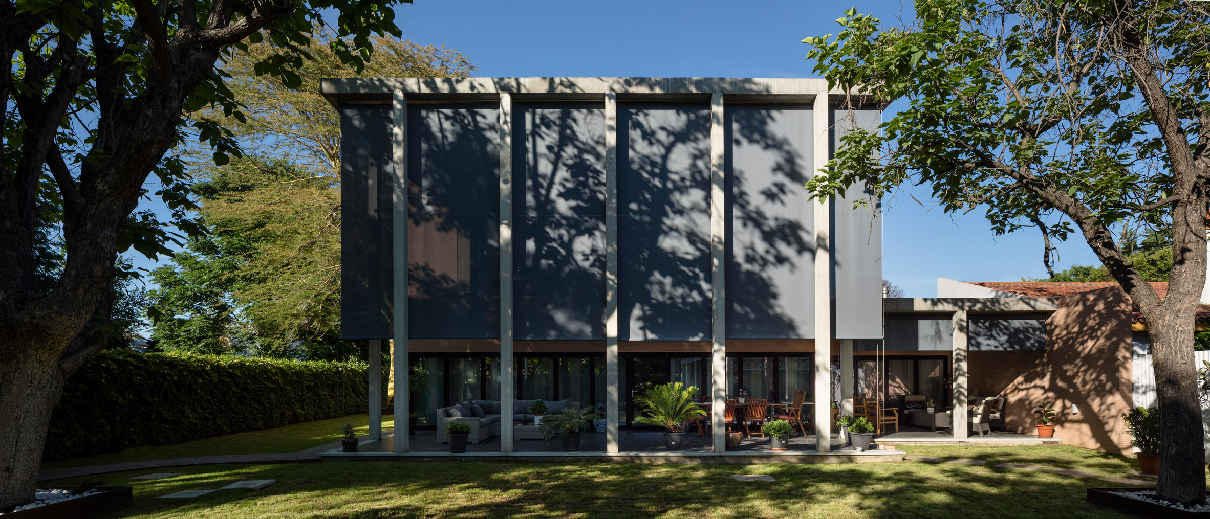 Concrete portico provides sheltered outdoor space at pink-brick house in Seville-24