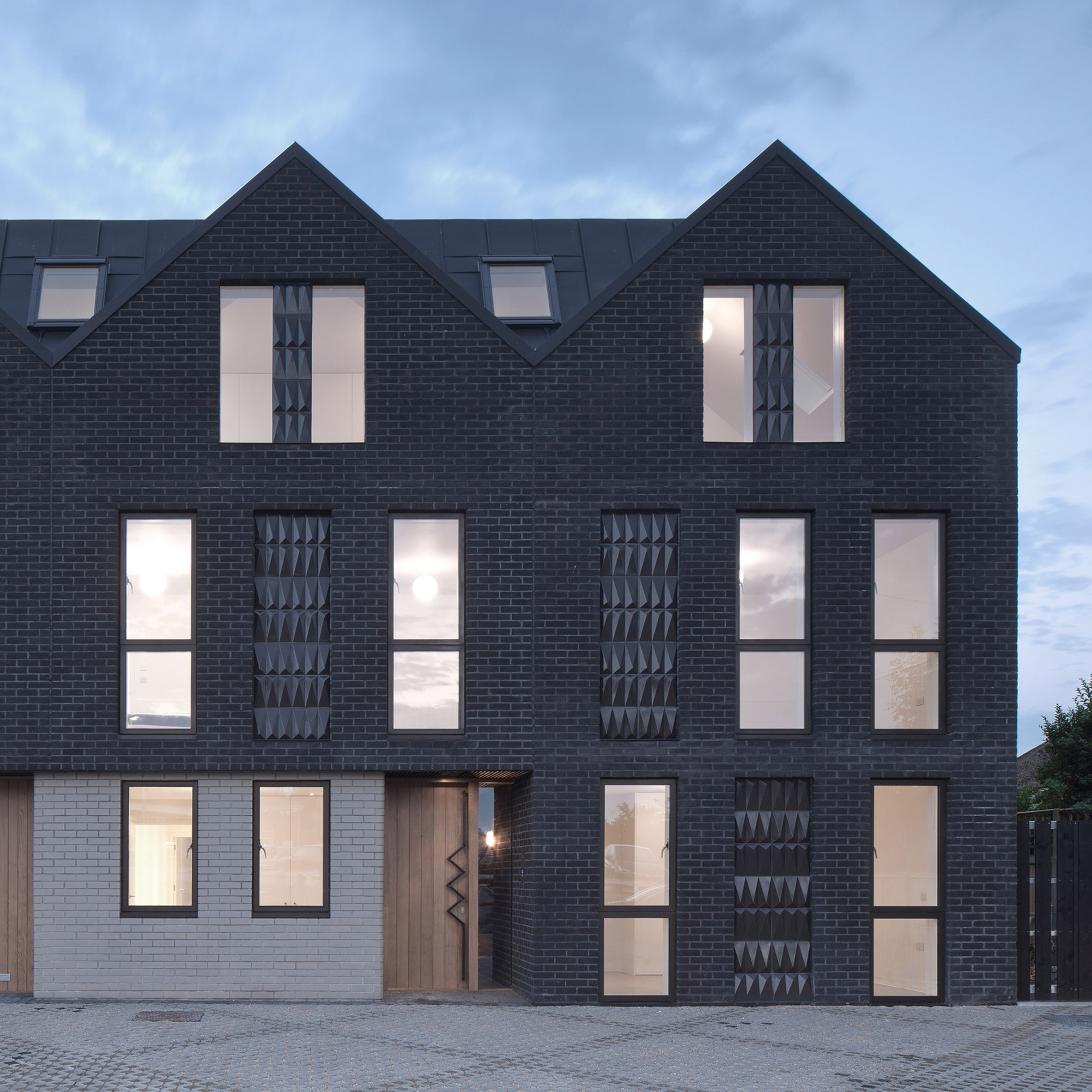 Denizen Works pairs black bricks with pointy panels for Whitstable housing-0