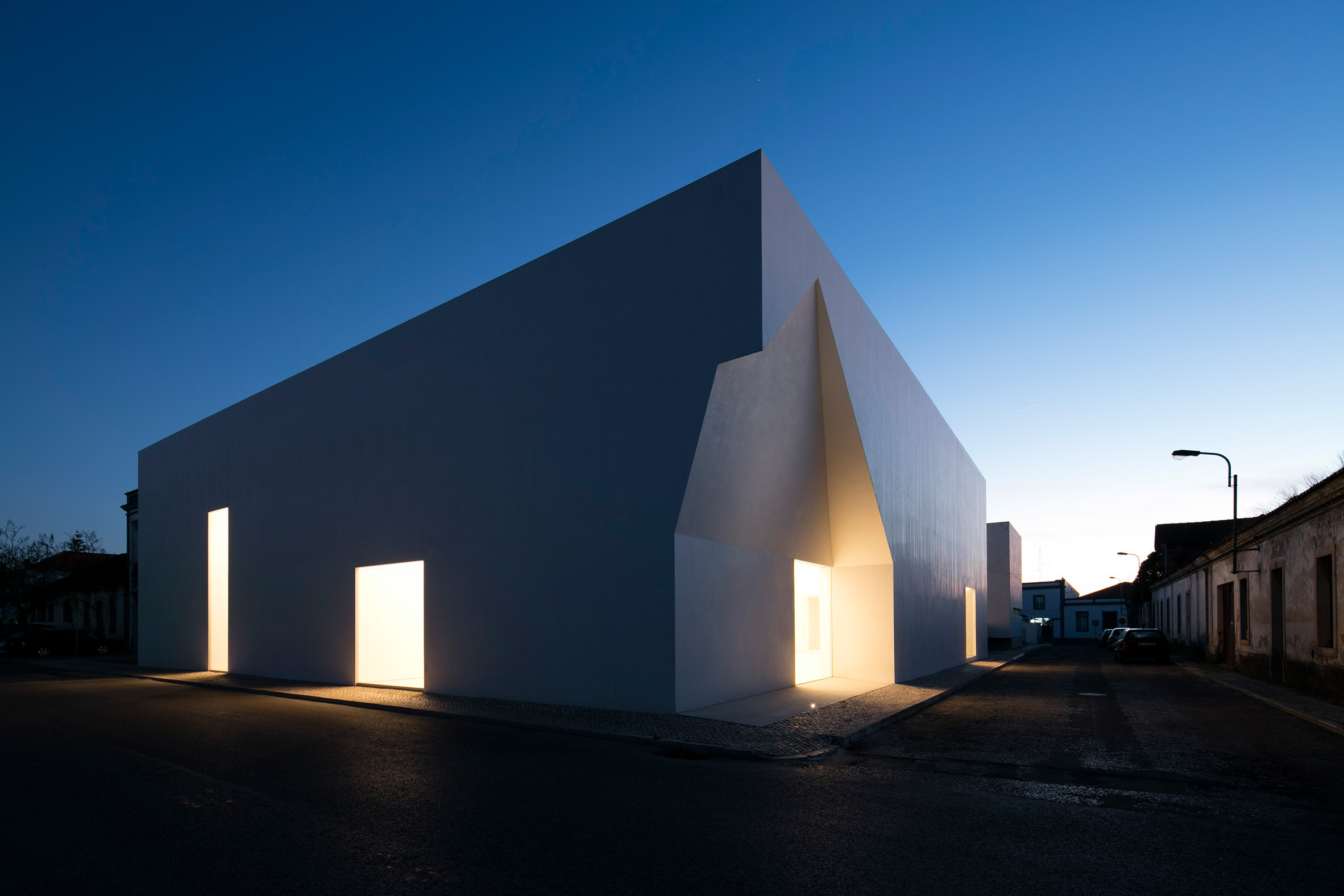 Irregular cutouts mark entrances to Aires Mateus' community centre in Portugal-18